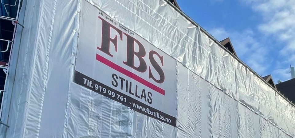 Image of a large scaffold delivered by FB Stillas | Bildet viser et stort stillas, levert av FBS. Skyer på himmelen i bakgrunnen. FBS - spesialist på lift og stillas.